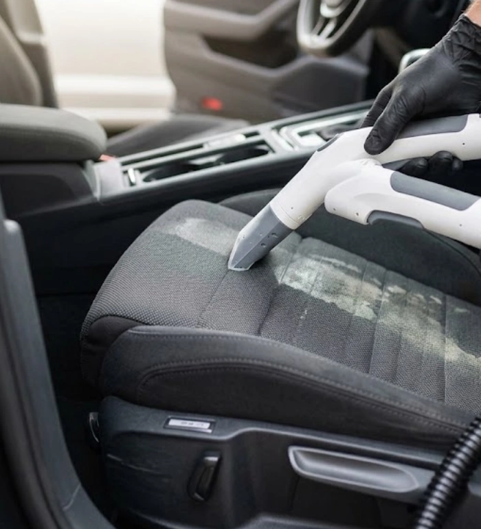 Shampouinage d’un siège en tissu lors d’un nettoyage intérieur de voiture